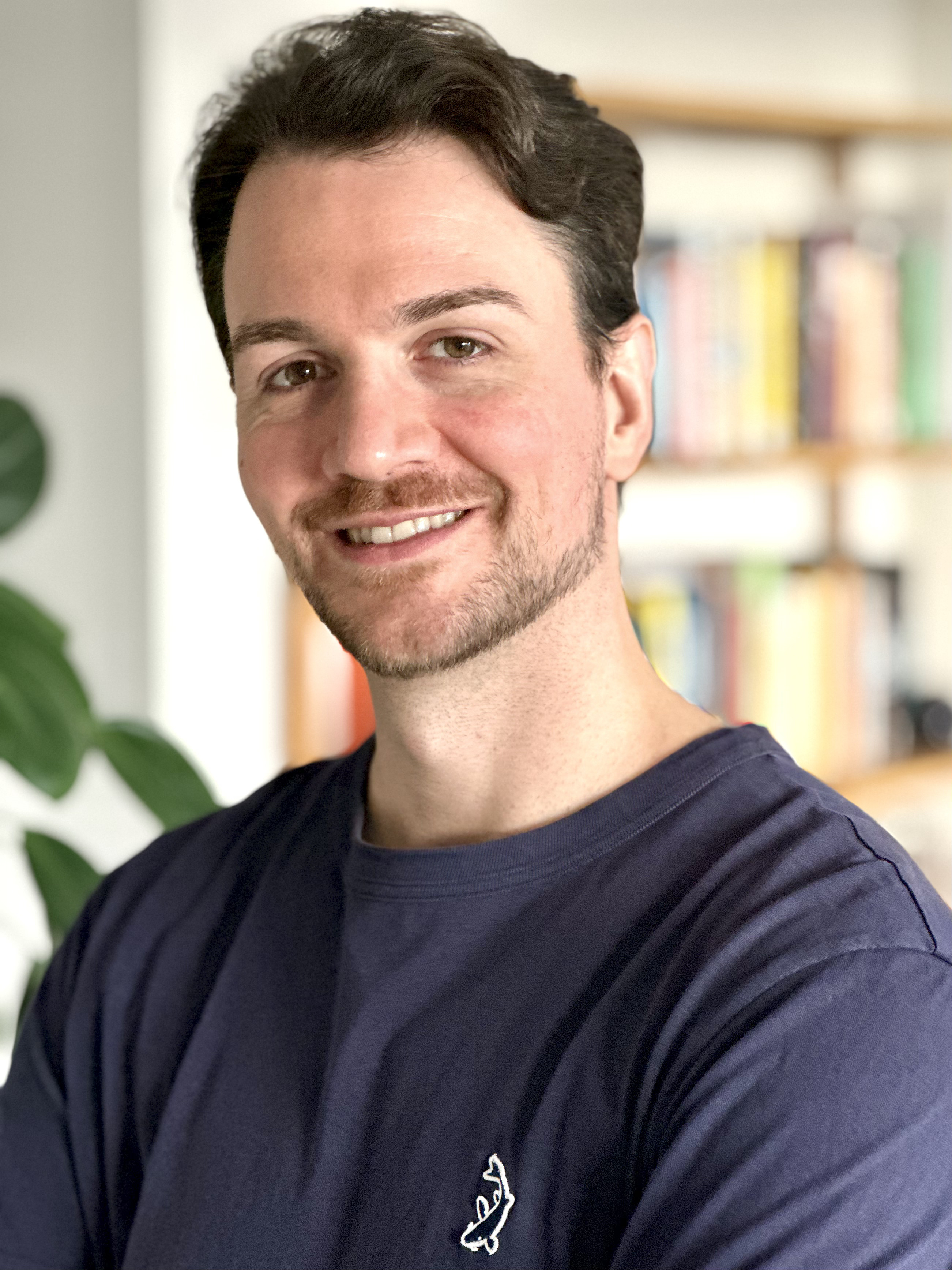 Portrait of a man smiling, dark hair, brown eyes, light skin and short beard